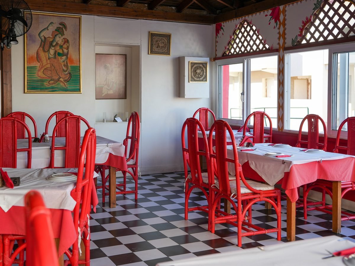 The dining room with red chairs and checkerboard floor