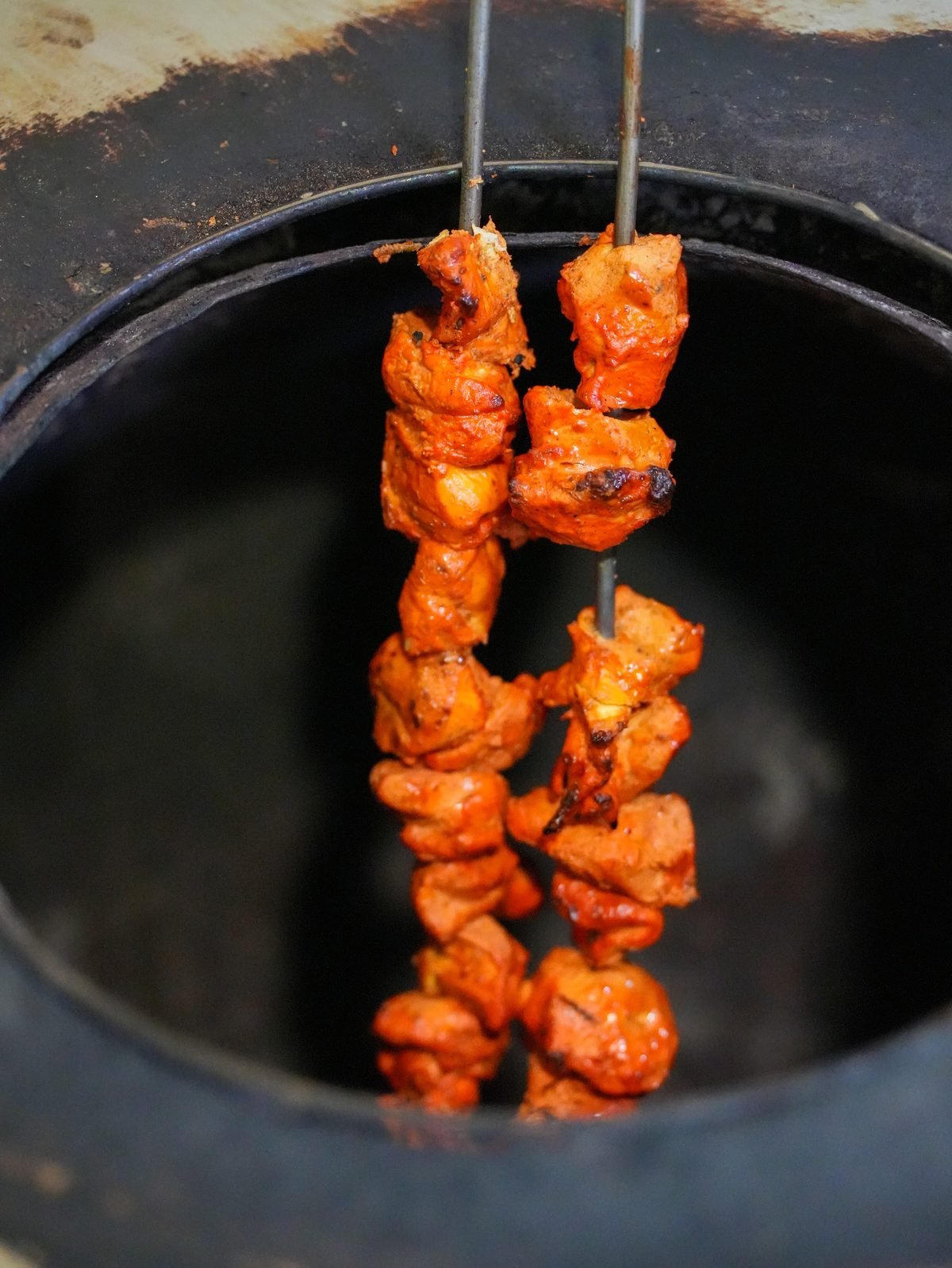 Marinated chicken skewers lifted from the tandoor oven