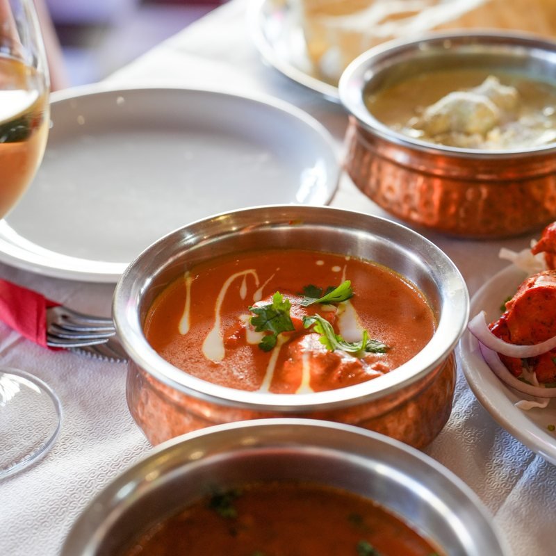 A fiery red curry with chilli in a copper bowl